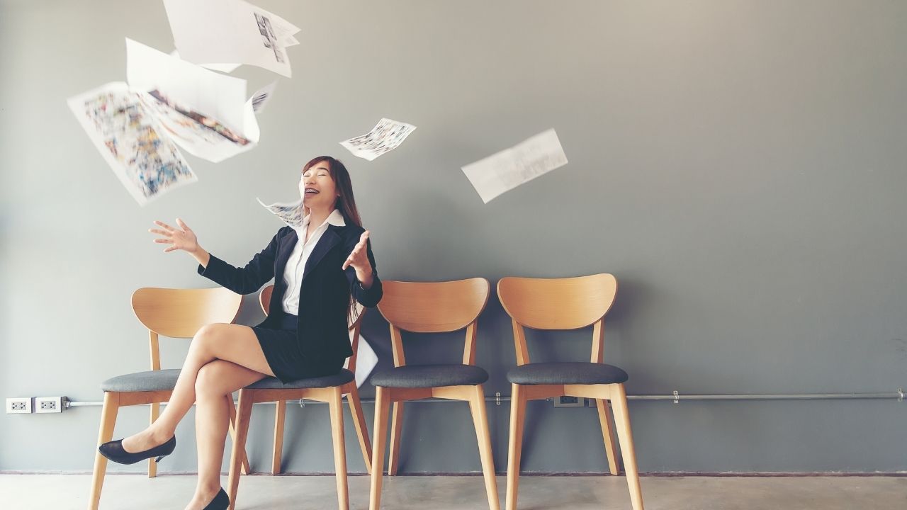 Asian woman tossing a bunch of papers